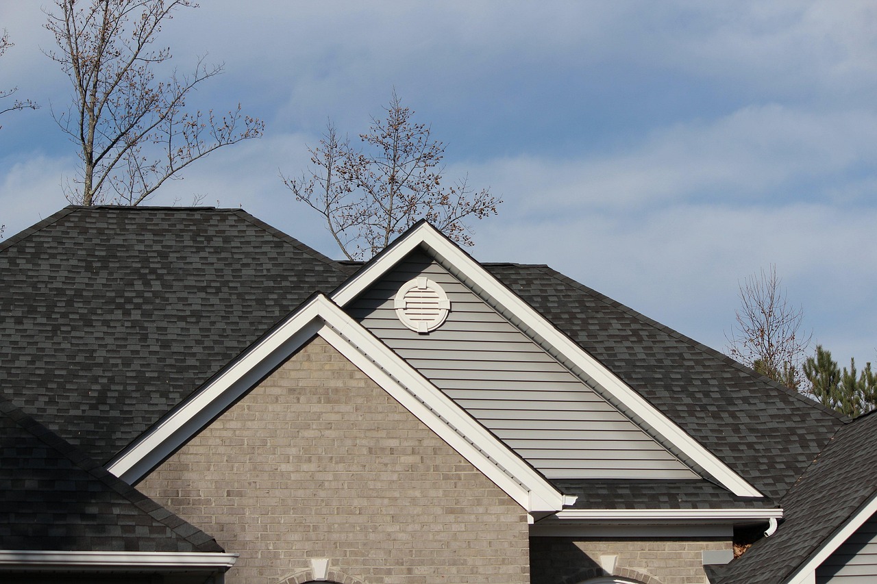 Gray asphalt shingle roof on a suburban house under summer sun, the kind of roof where cool roof shingles matter in Joshua, Texas