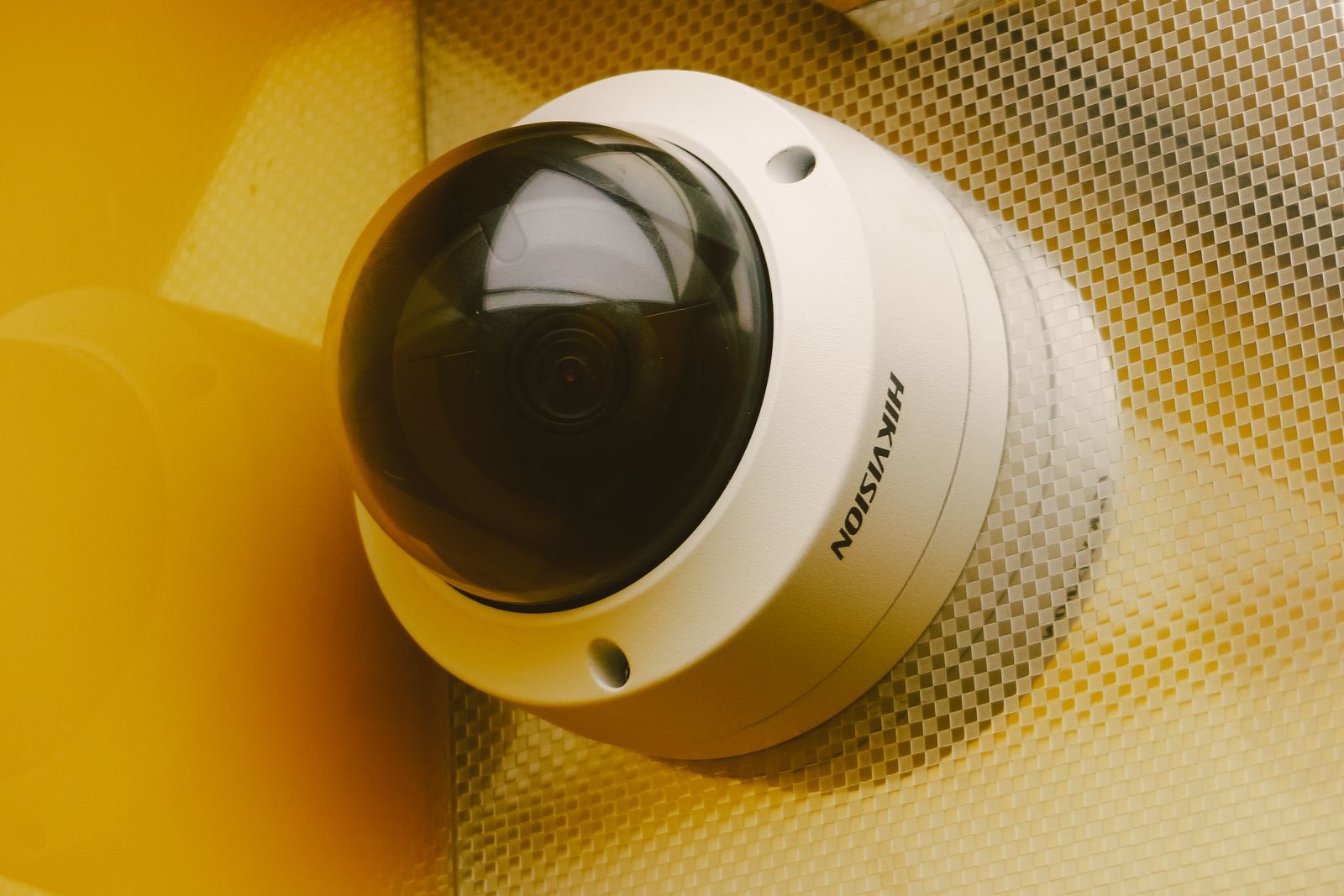 Exterior security camera mounted under the eaves of a home