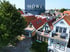 Dächer von Häusern und ein Baum mit blauem MÖWE IMMOBILIEN-Logo.