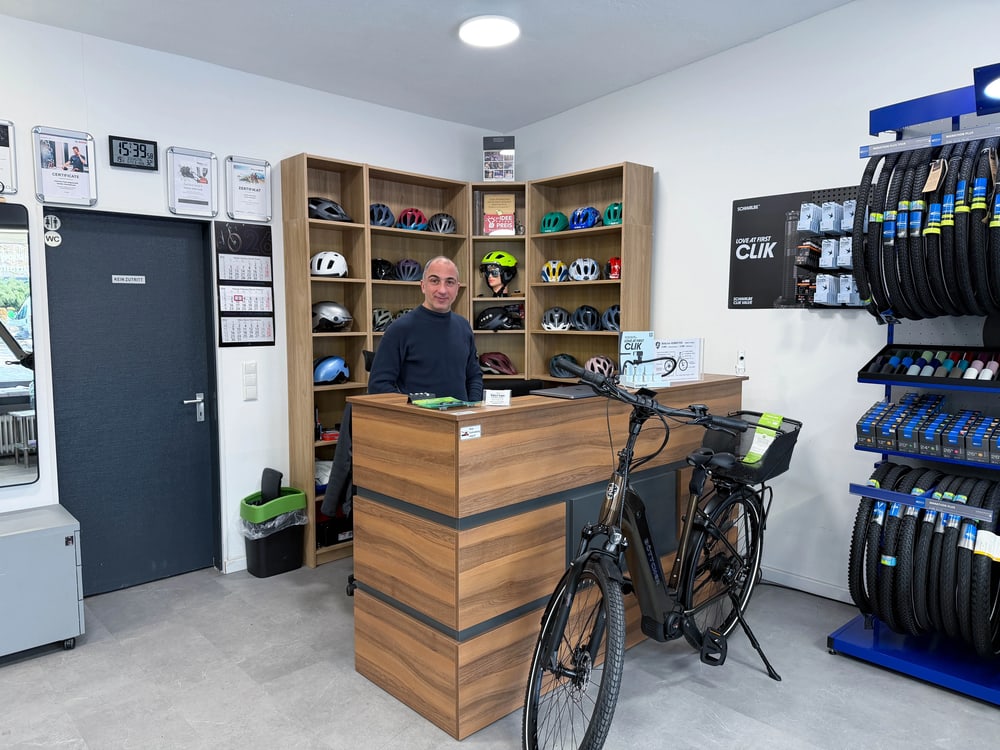 Vardan Abrahamyan hinter dem Holztresen im Veloman eBike-Center