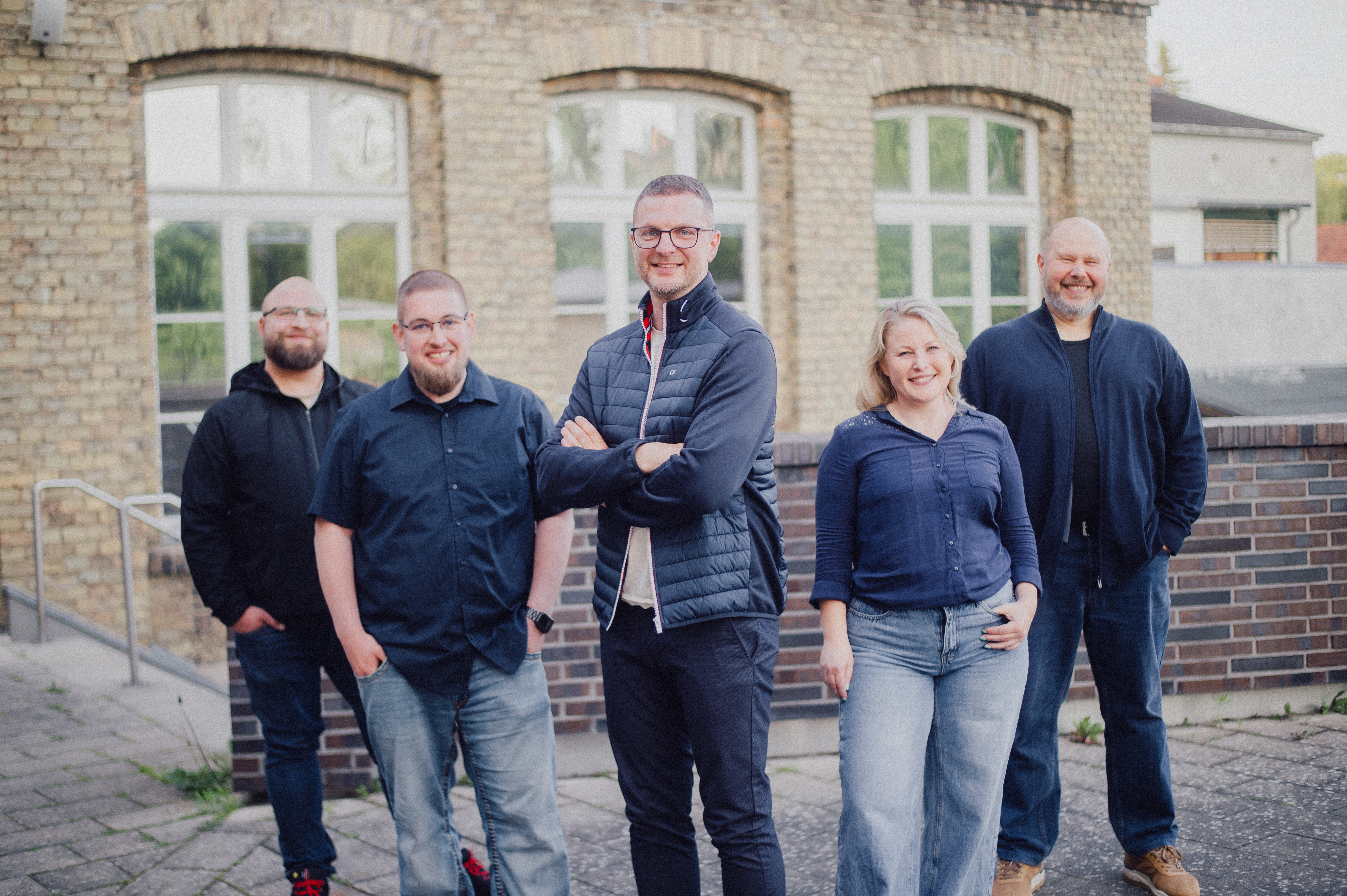 Team vor Backsteingebäude