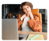 Woman at desk holds neck in pain while using laptop