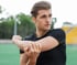 Man stretching his right arm to ease elbow pain