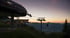 Eine Seilbahnstation bei Sonnenuntergang mit Gondeln und einem Bergpanorama.
