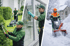Drei Männer in grünen Uniformen bei Hausmeisterdiensten: Rasenmähen, Fensterputzen, Schneefräsen im Winter.