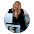 Webdesign-Team in Minden: lachende Designerin Chantal Haake am Schreibtisch mit Website auf dem Monitor