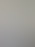 Ein teilweise gefliestes Badezimmer im Bau mit einer weißen Duschwanne und freiliegenden Rohren.