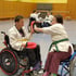 Personen beim Rollstuhl-Karate Training mit Partnerübungen in einer Sporthalle in Leipzig