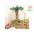 Bücherregal in Baumform mit grüner Blätterkrone, zwei Sitzbänken, Spielzeug und Teppich mit Blattmuster.