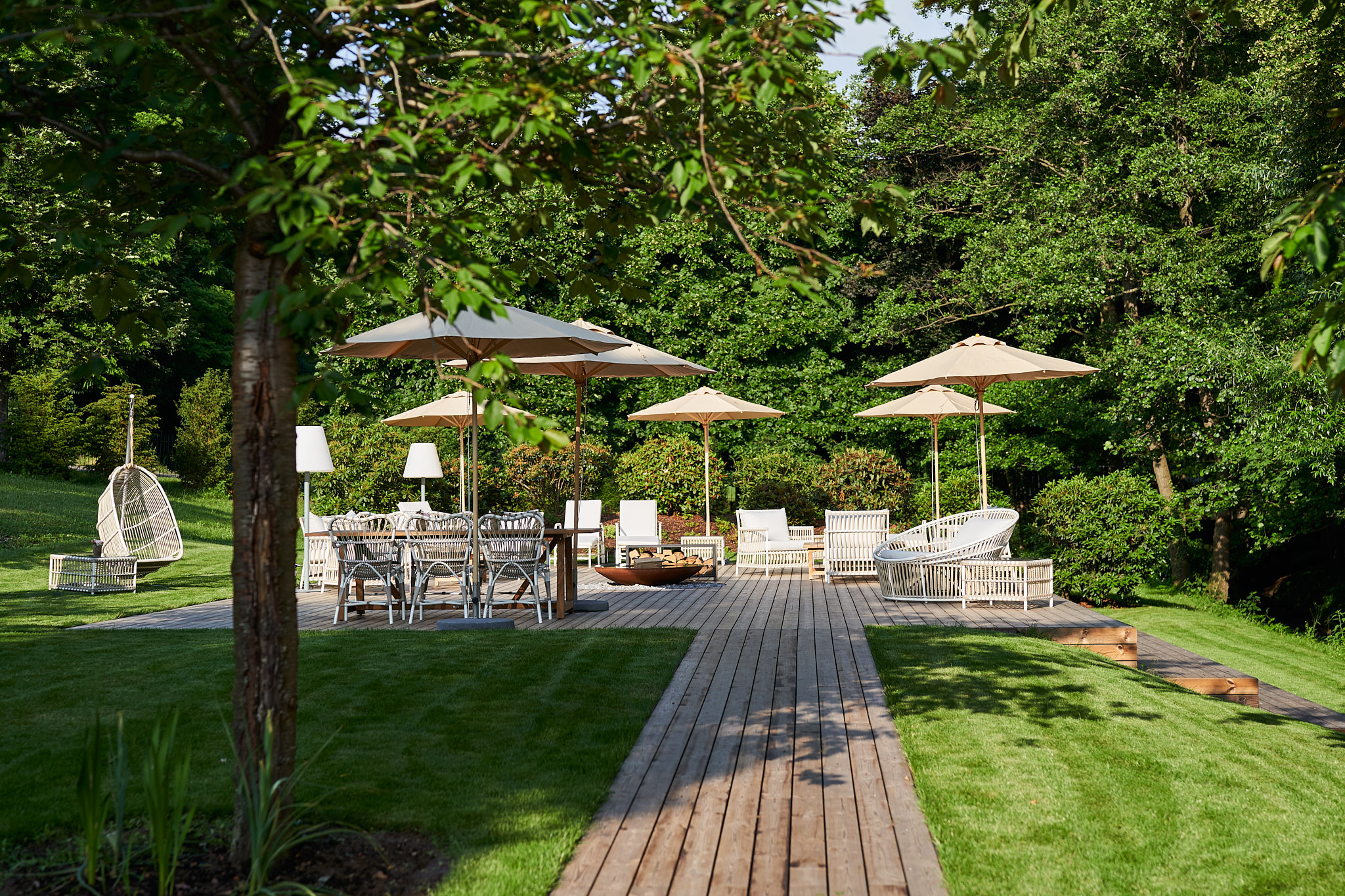Relais & Châteaux Hardenberg Burghotel – Holzterrasse mit Sitzbereich im begrünten Außenbereich