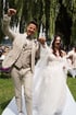 Ein glückliches Brautpaar läuft Hand in Hand auf einem weißen Teppich durch eine Gartenhochzeit.