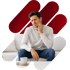 Man on a couch, grimacing and holding his cheek, indicating toothache or jaw pain.