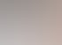 Modernes Hotelzimmer mit weißem Sessel, rundem Spiegel an einer Lamellenwand und einem Bett mit orangefarbenem Kissen.