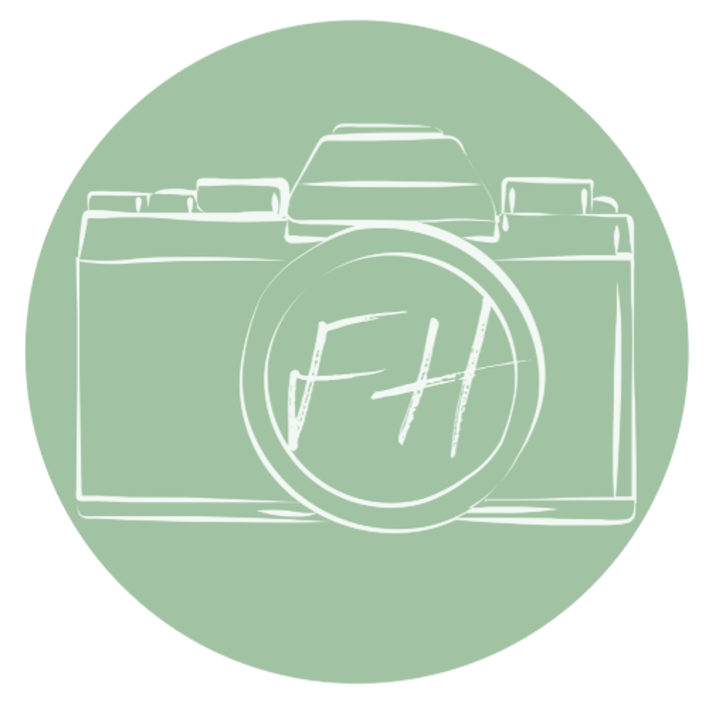 Grüne Kreissilhouette einer Kamera mit "FH" auf dem Objektiv.