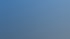 Blaues Wasser unter einem weiten Himmel mit weißen Cumuluswolken und einer entfernten Küstenlinie am Horizont.