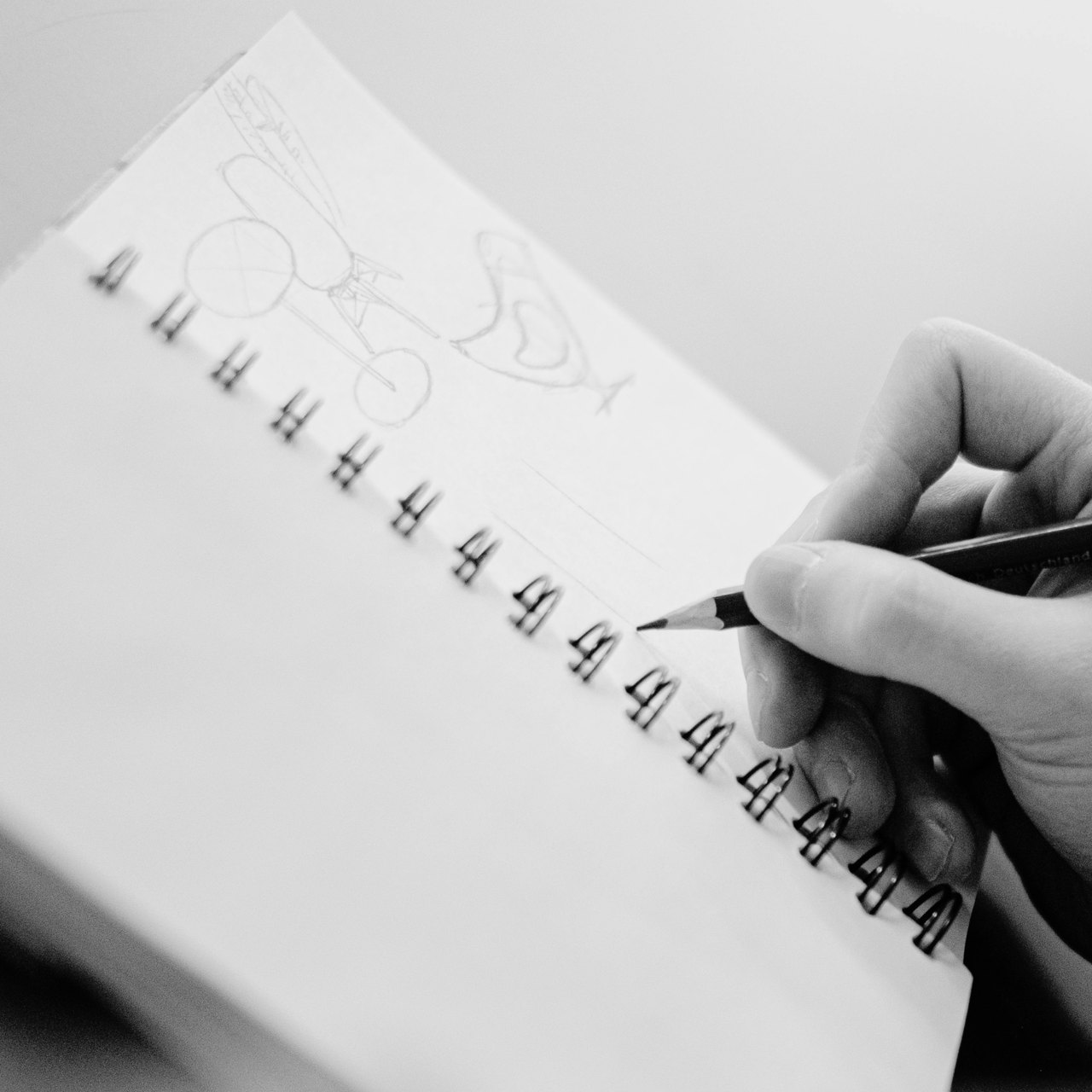 Hand skizziert mit Bleistift erste Logo-Entwürfe in einen Spiralblock
