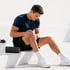 Regenerative sports recovery patient holds painful knee in gym setting