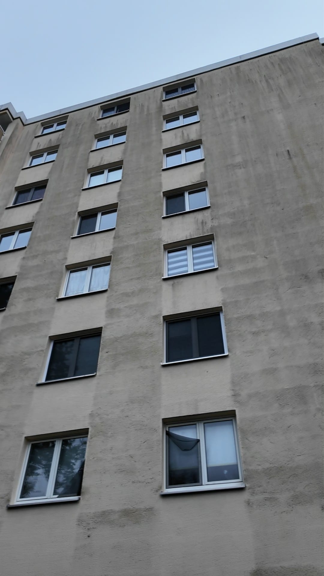 Mehrfamilienhaus vor der Reinigung, graue Fassade