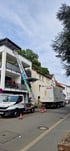 Zwei Zenith Umzüge Mitarbeitende entladen Umzugskartons aus dem Laderaum eines Transporters auf dem Firmengelände