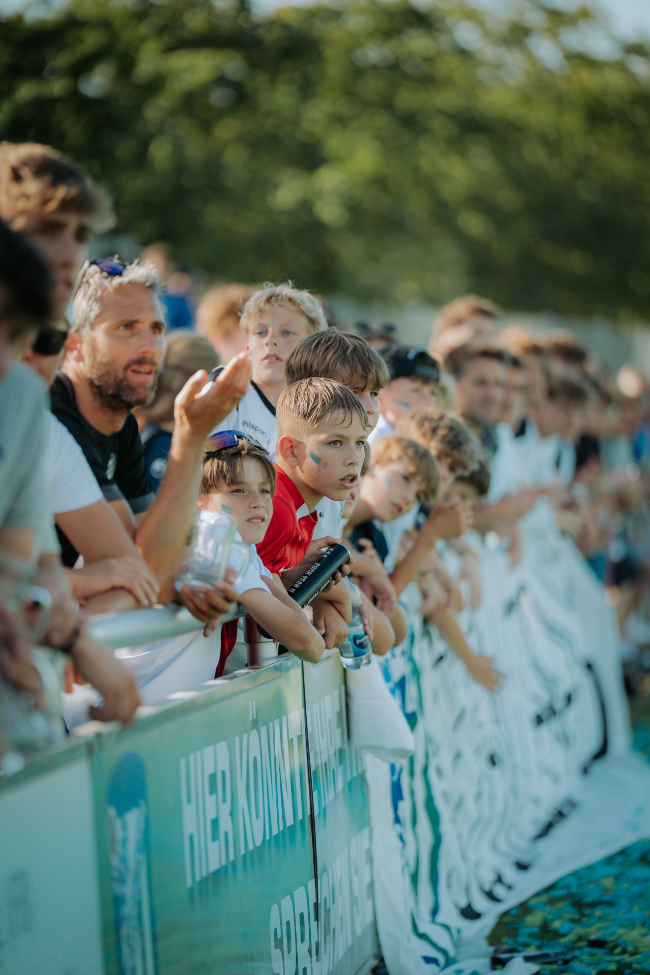 Junge Fans an der Bande, Wangen in Vereinsfarben