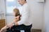 Michael Horn führt eine manuelle Lymphdrainage an der Schulter einer Patientin durch, während ihr Arm auf seinem Bein ruht