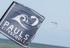 Pauls Kiteschule Flagge am Brouwersdam mit Kites im Hintergrund – Kitesurfen lernen in Holland