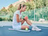Tennis player holding knee on court with acute sports injury