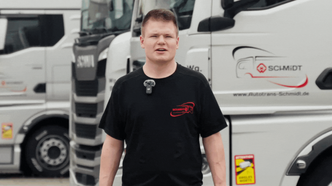 Mann, der vor einer reihe weißer LKWs steht und spricht