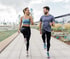 Man and woman jog gently on a path as they recover from a ligament tear