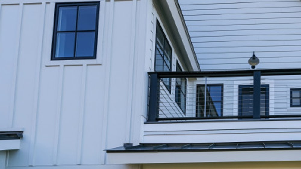 Modern metal balcony on a farmhouse style home.