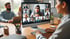Eine Frau nimmt an einer Videokonferenz mit mehreren Teilnehmern auf einem Desktop-Monitor teil.