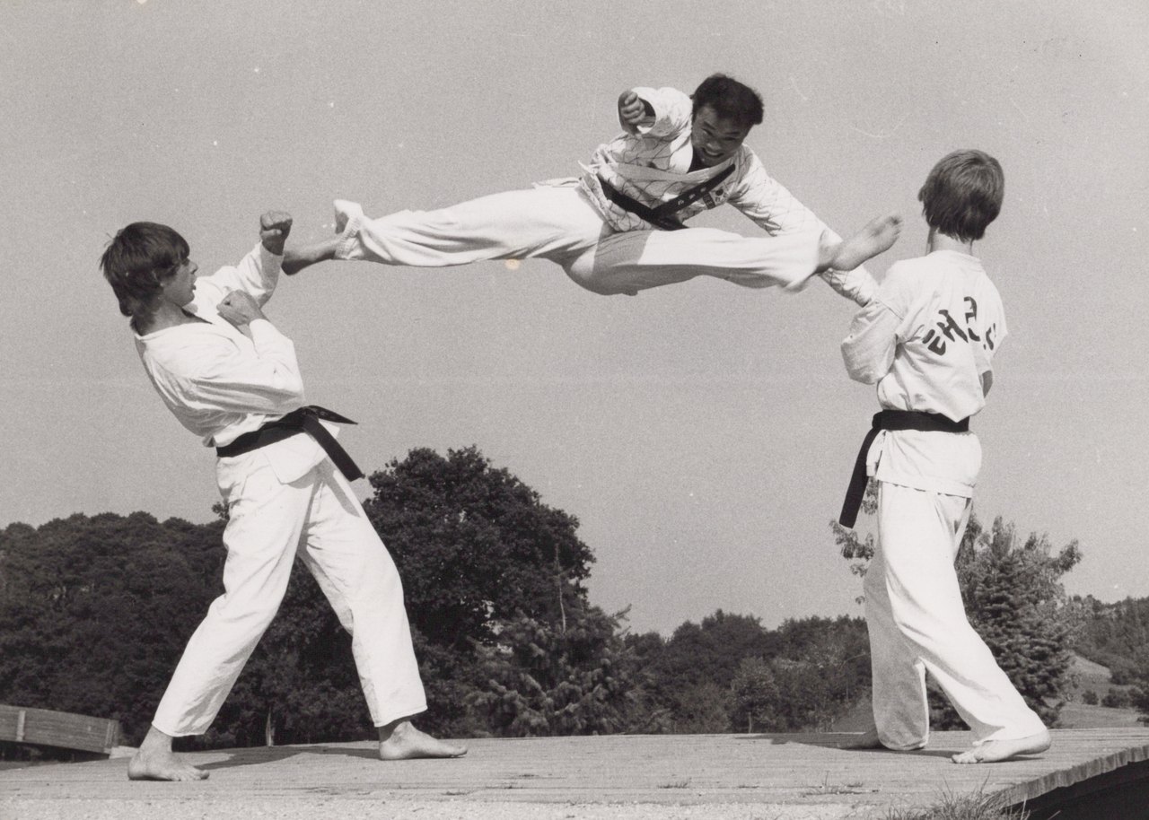 Großmeister Kim Chul-hwan beim Flugkick über zwei Schüler hinweg