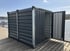 Dunkelgrauer Container mit offener Tür, bestehend aus zwei Elementen, steht auf einem Holzsteg am See.
