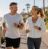 Smiling couple jogging by the ocean supporting SS-31 peptide therapy.