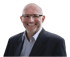 Ein lächelnder Mann mit Brille, Glatze und blauem Sakko über einem gestreiften Hemd.
