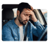 Man in car holding forehead, suffering from whiplash injury