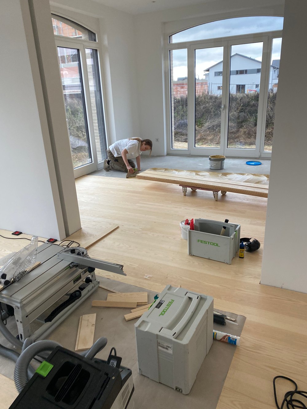 Parkettverlegung mit Holzparkett und vorbereiteter Klebefläche auf einer Baustelle