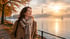 Frau im Herbstmantel an der nebligen Alster im goldenen Morgenlicht (KI generiertes Bild)