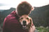 Ein Mann umarmt glücklich seinen jungen Golden Retriever