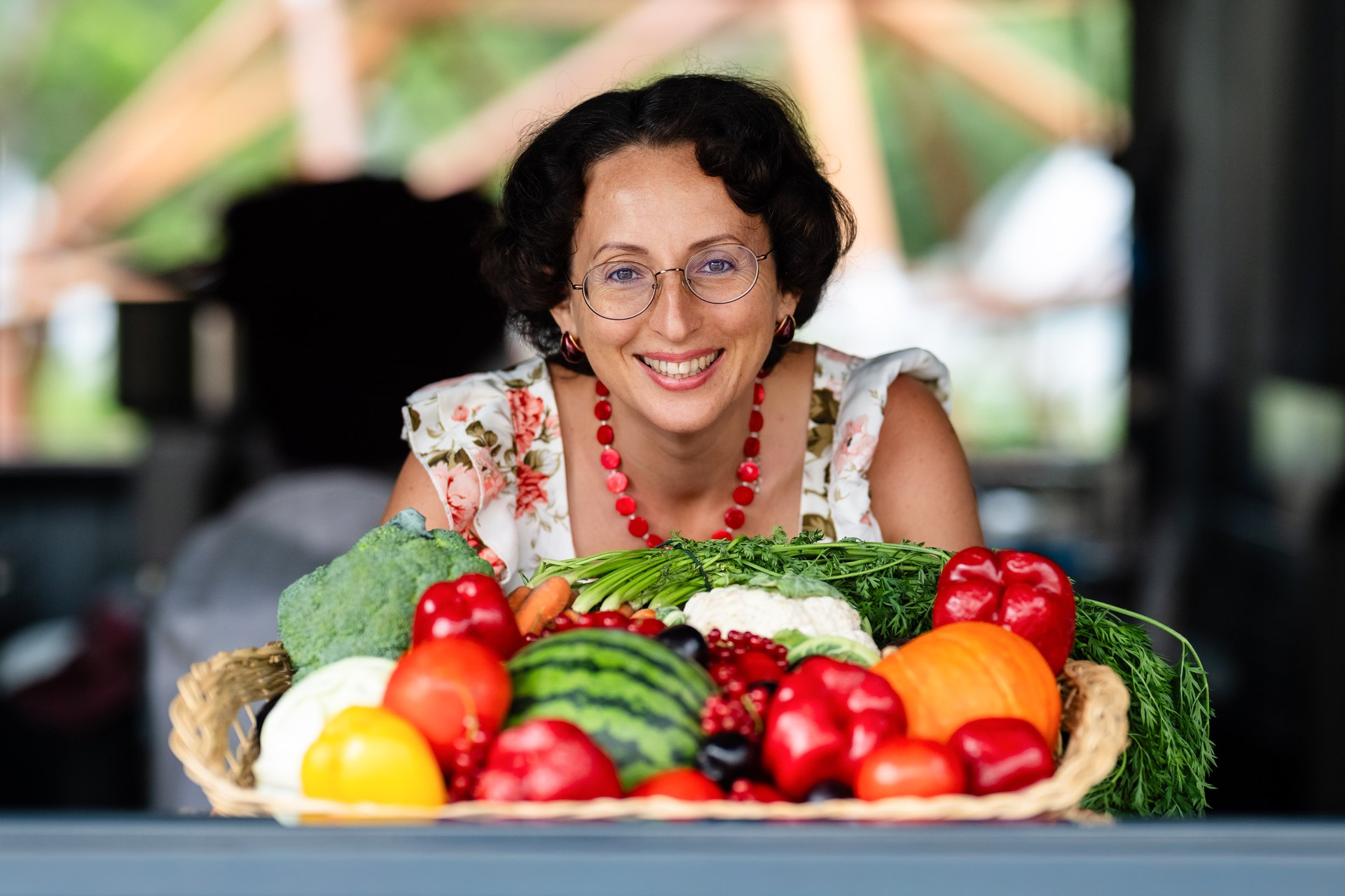 Nadia Krol hinter einem Korb mit frischem Gemüse und Obst