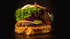 Ein großer Burger mit zwei Fleischpatties, geschmolzenem Käse, Salat, Zwiebeln, Tomaten und Gurken.