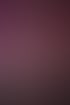 Nahaufnahme einer lächelnden Frau mit dunklen Haaren und schwarzem Trägertop vor violettem Hintergrund.