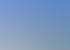 Modernes weißes Haus mit großen Fenstern und blauen Glasbalkonen unter blauem Himmel.