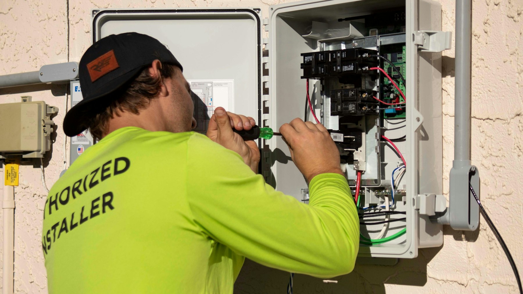 EVITP-certified installer working inside an electrical panel on an EV charger circuit