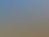 Ein Mann und ein Hund liegen im hohen Gras unter blauem Himmel.