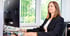 Frau im schwarzen Blazer und weißem Oberteil arbeitet am HP Computer mit zwei Monitoren.