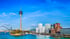 Düsseldorf Skyline mit Rheinturm, Medienhafen und Gebäuden am Flussufer unter blauem Himmel.
