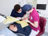 Zahnarzt und Assistentin behandeln eine Patientin auf dem Behandlungsstuhl in einer modernen Zahnarztpraxis.
