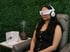 Woman using BrainTap therapy with headset and relaxation wellness setup