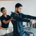 Physical therapist assists a male patient focusing on shoulder rehabilitation as part of a holistic medicine approach.